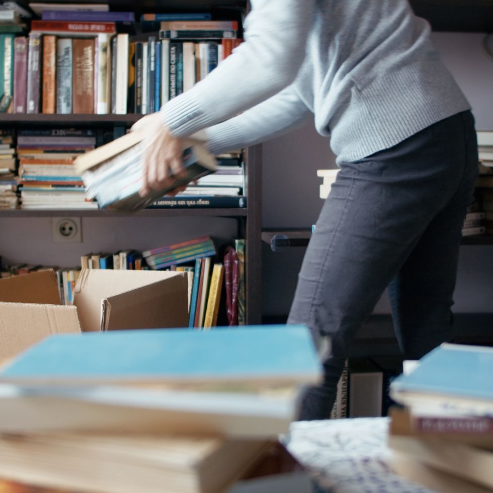 swedish death cleaning, woman packing boxes with books